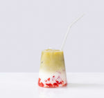 Last inn bildet i Galleri-visningsprogrammet, Glass med lagdelt matcha, melk og røde biter, servert med sugerør.