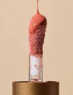 Last inn bildet i Galleri-visningsprogrammet, Leppeolje applikator med rosa fargetone mot beige bakgrunn.
