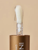 Last inn bildet i Galleri-visningsprogrammet, Leppeolje med applikatorstav mot beige bakgrunn.
